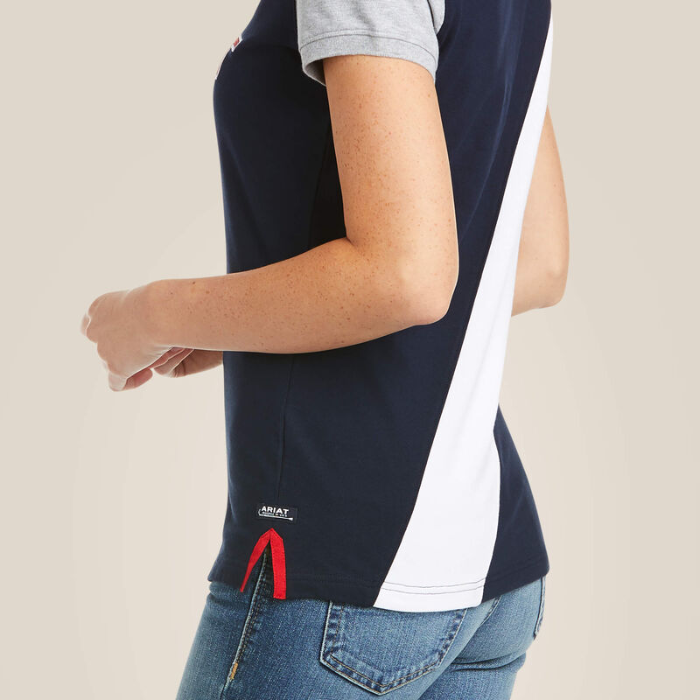 Close up of a navy polo shirt with white stripe and branding on a plain background