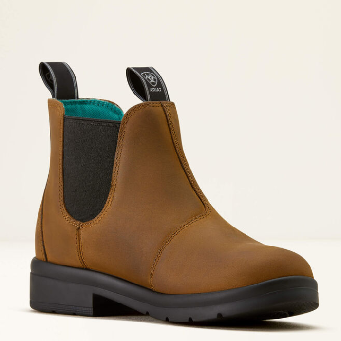 Brown leather boot with black sole on a beige background