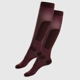 Pair of maroon knee-high socks on a light grey background