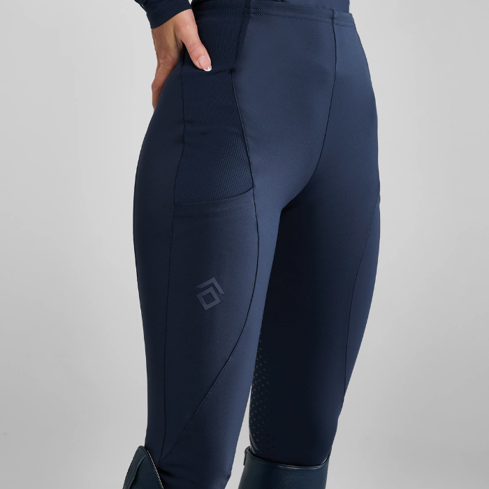 Navy blue riding leggings with a brand logo on a grey background