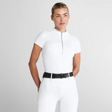 Woman wears a white short sleeve base layer and white breeches on a light grey background