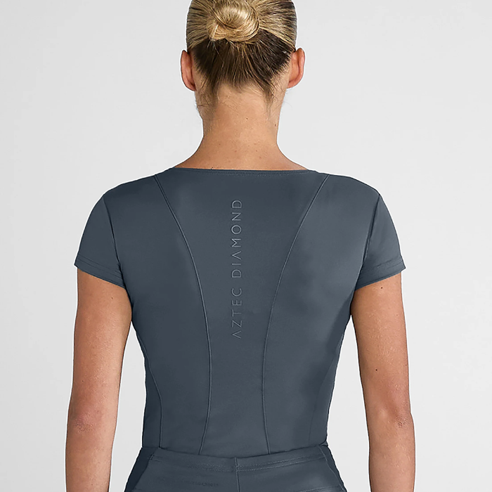Person wearing a dark grey outfit with 'Aztec Diamond' branding on the back against a light grey background