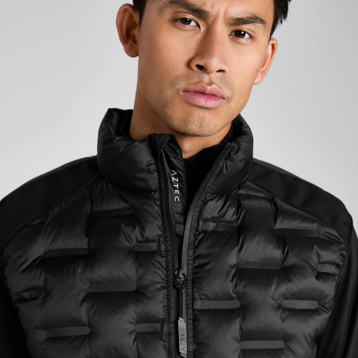 Man wearing a black gilet with AZTEC branding on a grey background