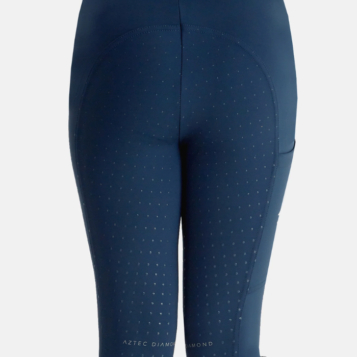 Close up of textured material on navy riding legging on a grey background