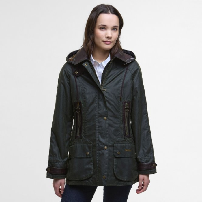 Woman wearing a dark green Barbour jacket with brown accents on a white background
