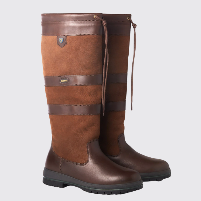 Pair of brown leather boots with a visible brand logo on a light grey background
