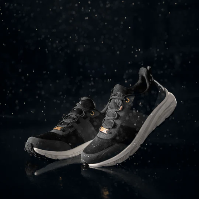 Black training shoes against a dark backgriound
