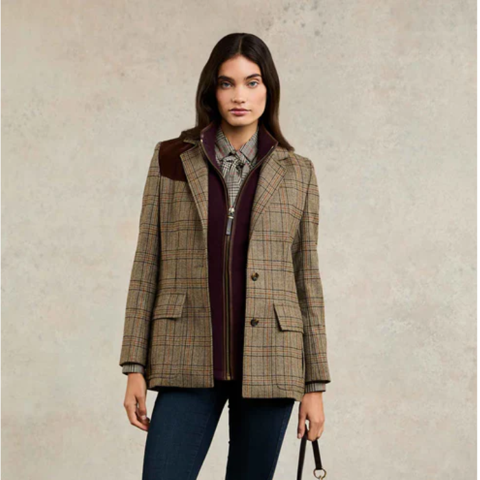 Woman wearing a plaid jacket with a plain background