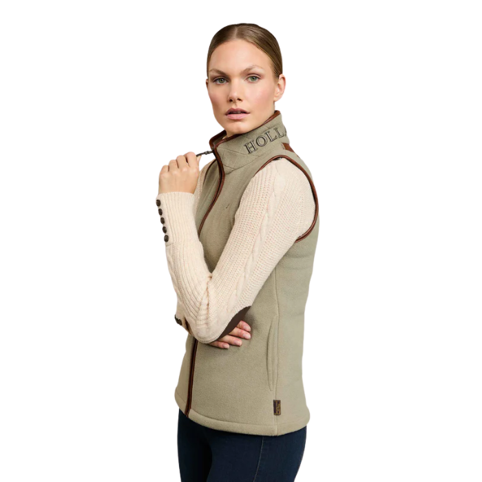 Woman wearing a green vest with a brand logo on a white background