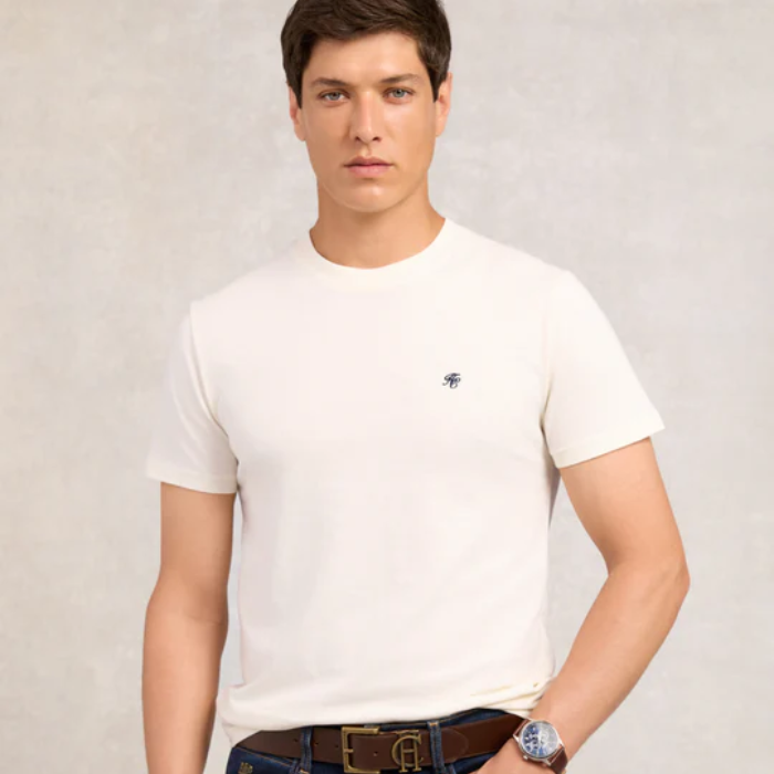 Man wearing a white t-shirt with a small HC logo on a plain background