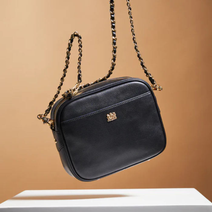 Black handbag with a chain strap on a beige background