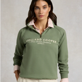 Woman wearing a green Holland Cooper sweatshirt on a plain background