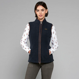 Woman wearing a navy fleece gilet over a patterned shirt on a grey background