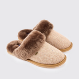 Pair of slippers with brown fur trim on a light grey background