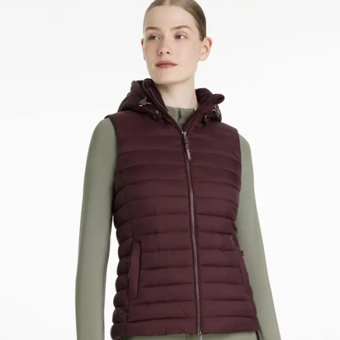 Woman wearing a maroon puffer gilet on a white background