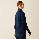 Woman wearing a navy blue long-sleeve shirt against a beige background