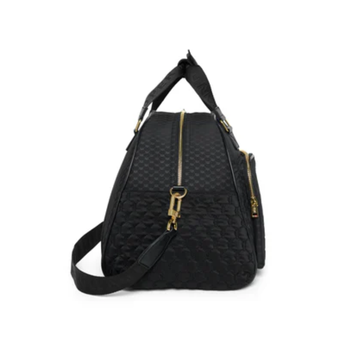 Black quilted bag with gold zippers on a white background