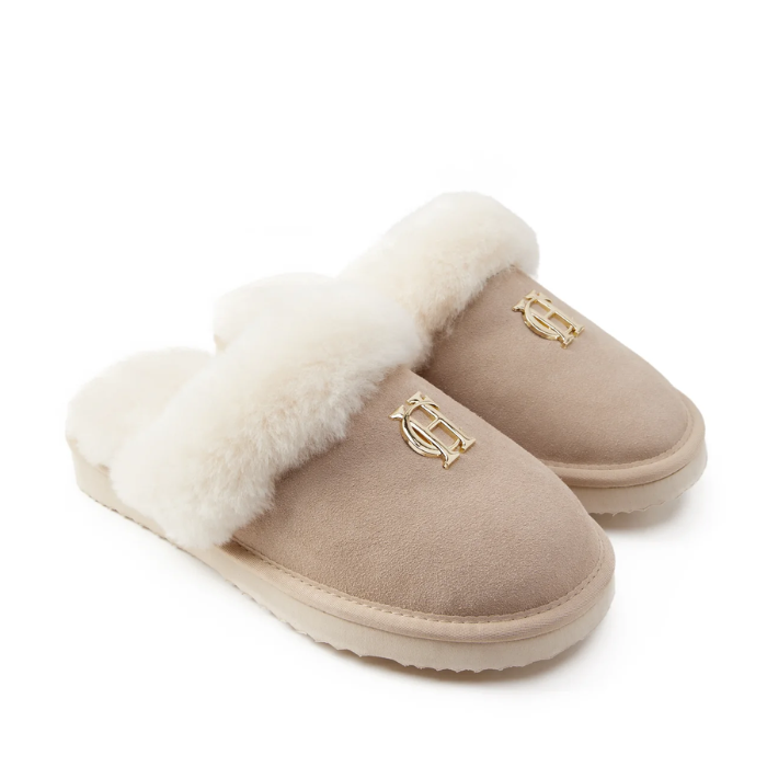 Pair of beige slippers with white fur lining on a white background