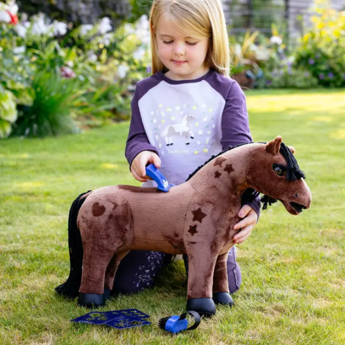 Child playing with a plush horse toy outdoors