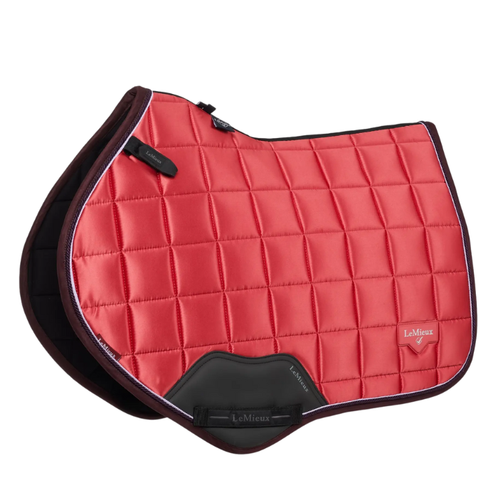 Red quilted saddle pad with black border on a white background