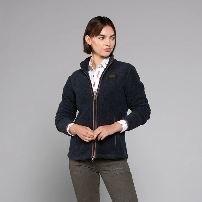 Woman wearing a navy fleece jacket on a grey background
