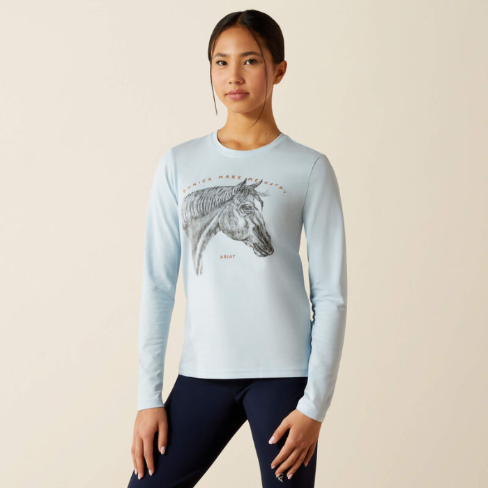 Woman wearing a light blue long-sleeve shirt with a horse graphic on a beige background