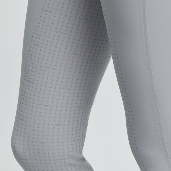 Close-up of grey leggings with a subtle pattern on a light grey background