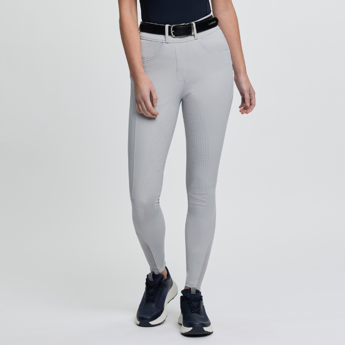 Person wearing grey riding leggings with a black belt on a light grey background