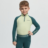 Child wearing a green and light green LeMieux outfit on a white background