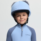 Child wearing a blue equestrian helmet and matching outfit with 'LeMieux' branding on a light grey background.