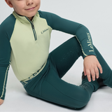 Child wearing a green and beige equestrian outfit with 'LeMieux' branding on a white background