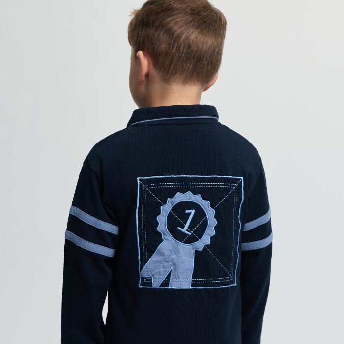 Navy blue shirt with a logo on the back worn by a child, on a light grey background