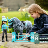 Child playing with toy horse and rider figures outdoors