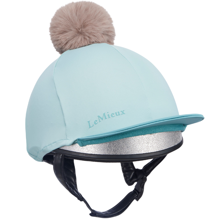 Pale blue equestrian helmet with brown fur pom-pom and 'Lemieux' logo on a white background