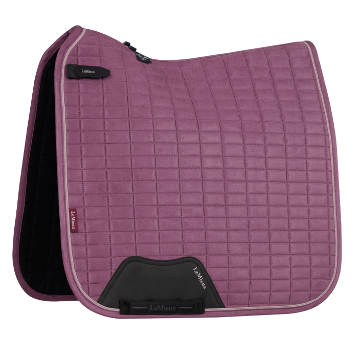 Pink quilted saddle pad with visible brand logo on a white background