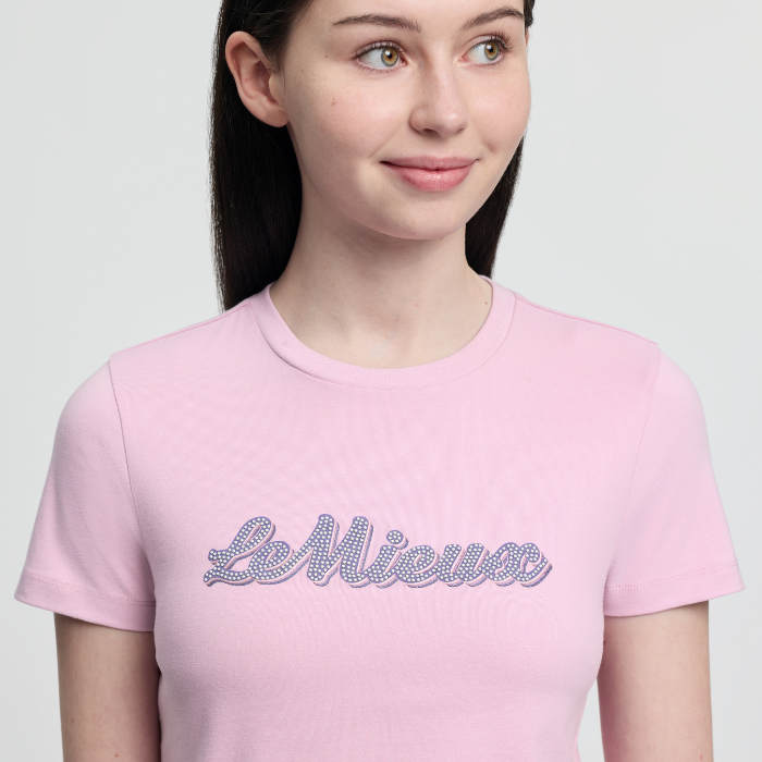 Person wearing a pink t-shirt with 'Le Mieux' text on a light gray background