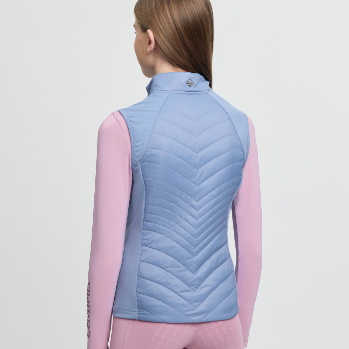 Person wearing a blue quilted vest on a light grey background