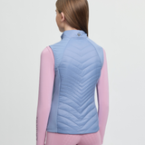 Person wearing a blue quilted vest on a light grey background