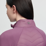 Person wearing a pink quilted jacket with a brand logo on a light grey background