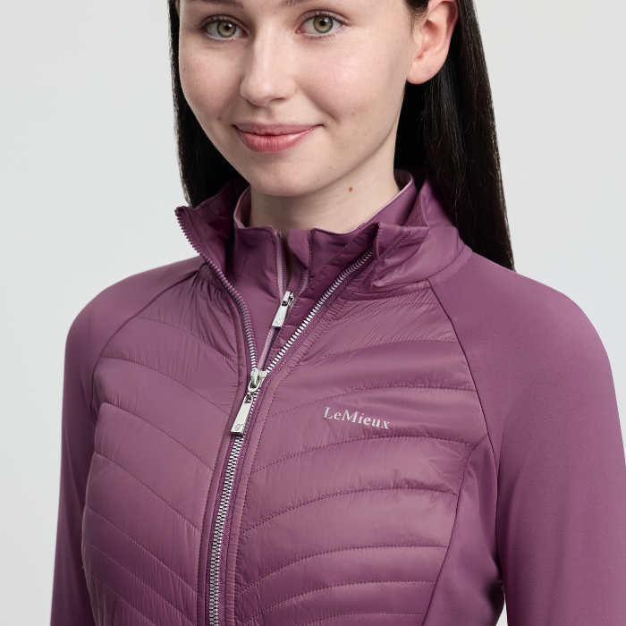 Person wearing a pink quilted jacket with 'LeMieux' branding on a light grey background