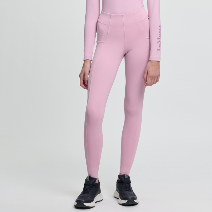 Person wearing pink leggings with a logo on a light grey background
