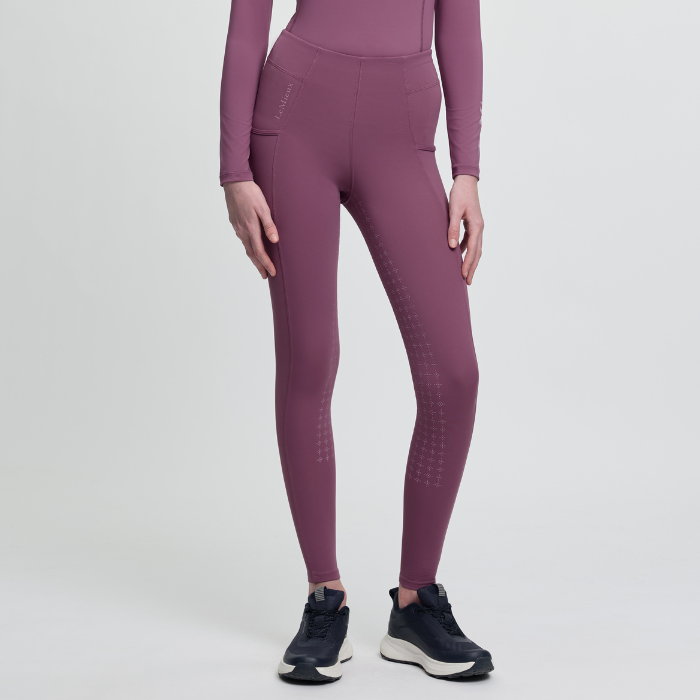 Person wearing pink athletic leggings and top on a light grey background
