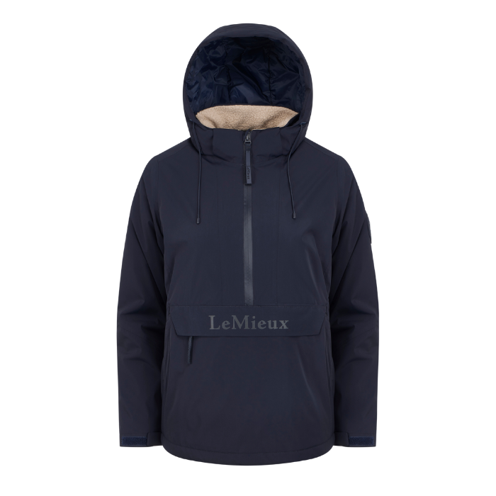 LeMieux AW26 Phoebe Half Zip Waterproof Anorak Varient Navy. A navy blue hooded jacket with a beige sherpa lining visible inside the hood, featuring a front zipper, drawstrings, and a front pocket with the brand name 'LeMieux' printed on it.