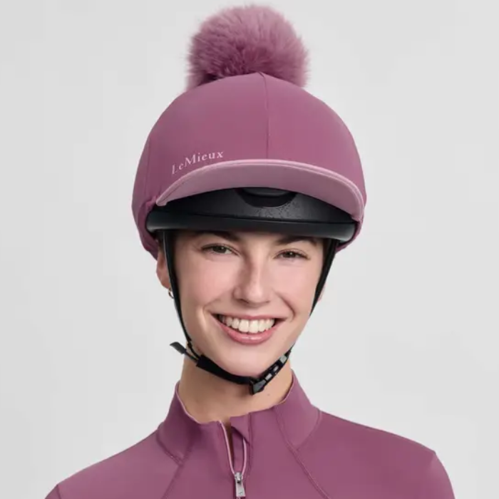 Person wears a dark pink helmet cover and top on a plain background