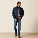 Man wearing a navy jacket with a brand logo, standing against a plain background