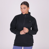 Woman wearing a black sweatshirt with a small logo on a light grey background