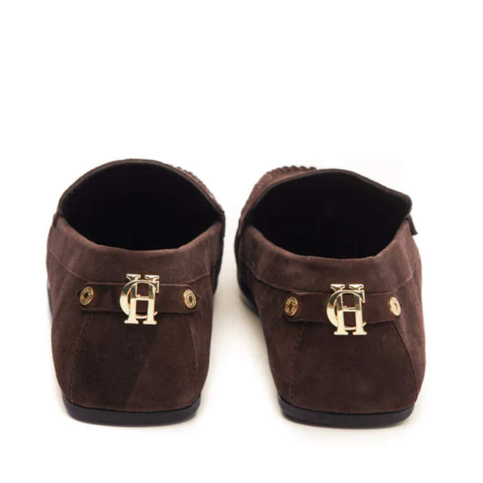 Brown loafers with gold HC detailing on a white background