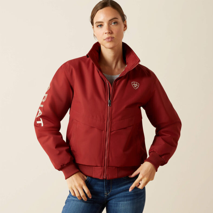 Woman wearing a brown jacket with a logo on a beige background