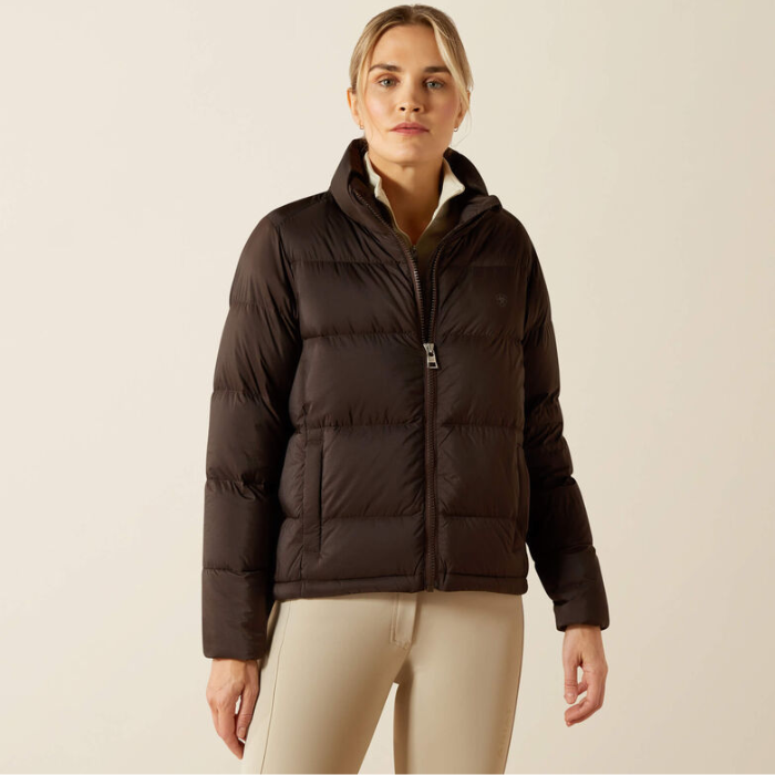 Woman wearing a brown puffer jacket on a beige background