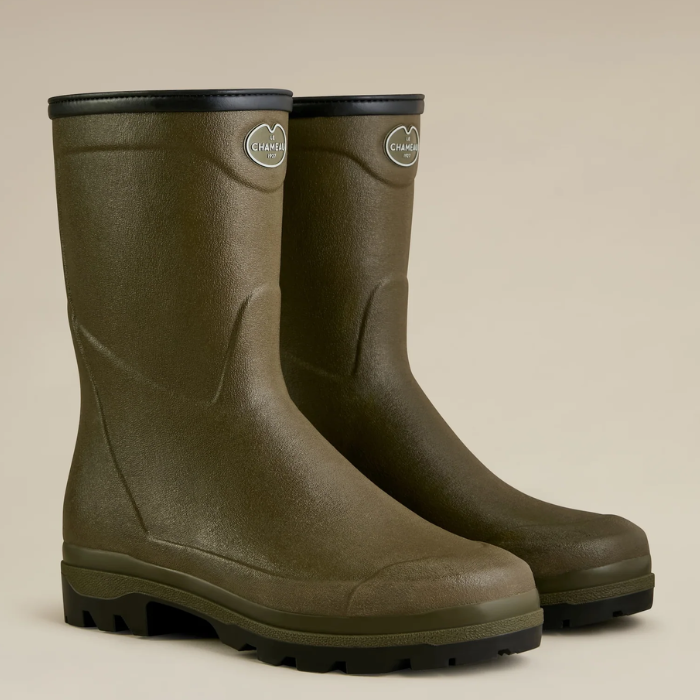 Pair of green short wellington boots on a beige background